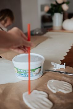 someone is making handprints out of paper on a table with scissors and glue