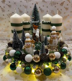 three lit candles sitting on top of a table with christmas decorations and ornaments around it