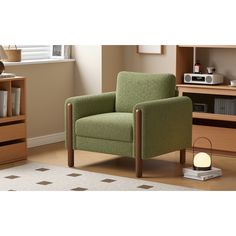 a green chair sitting on top of a wooden floor next to a book shelf filled with books