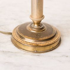 an antique brass table lamp on a marble surface