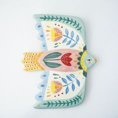 a ceramic bird decoration on a white wall