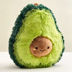 an avocado stuffed animal with a smile on it's face and eyes