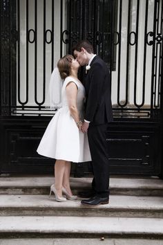 a bride and groom kissing on the steps