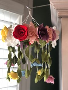 a mobile made out of felt flowers hanging from a string