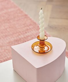 a candle is sitting on top of a pink box