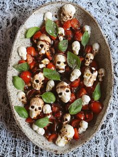 a bowl filled with tomatoes and cauliflower on top of a lace table cloth