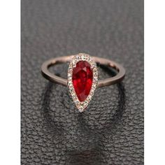 a ring with a pear shaped red stone surrounded by diamonds