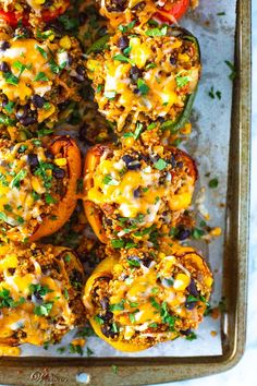 stuffed bell peppers on a baking sheet with toppings