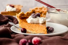 a slice of pumpkin pie with whipped cream and cranberries