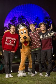 four people posing for a photo with a dog mascot