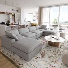 a living room filled with furniture next to a kitchen and dining room table on top of a rug