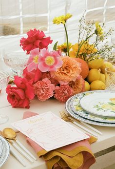 the table is set with flowers and plates