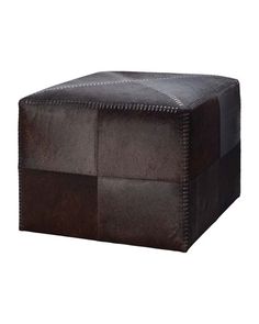 a brown leather ottoman with stitching on the top and bottom, sitting in front of a