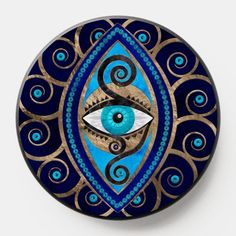 an eye painted on top of a blue and gold wall plate with swirls around it