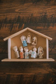 a doll house with many items in it on a wooden shelf above a table top