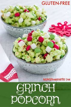 two bowls filled with green and red candy popcorn on top of a white tablecloth