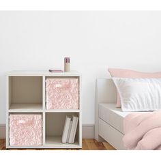 a white bed sitting next to a book shelf on top of a hard wood floor