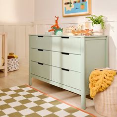 a baby's room with a dresser and crib