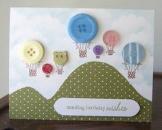 a birthday card with buttons on it and some clouds in the sky behind them,