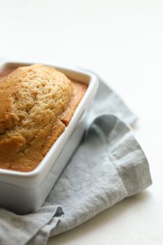 a close up of a muffin in a pan on a cloth with a napkin