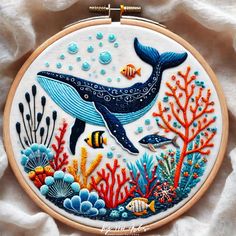 an embroidery pattern with a blue whale and corals in the water on a white background