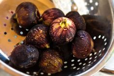 a metal colander filled with ripe figs