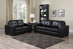 a living room with two black leather couches