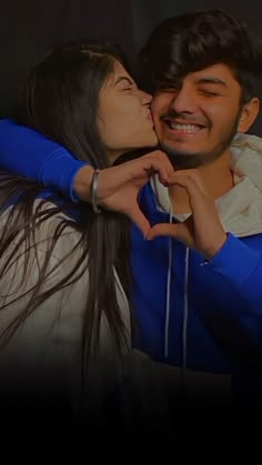 a man and woman standing next to each other in front of a black background with the words love written on it