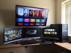 two computer monitors sitting next to each other on top of a wooden desk in front of a window