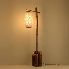 a lamp that is sitting on top of a table next to a light fixture with bamboo shades