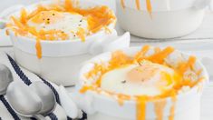 two white bowls filled with food on top of a table