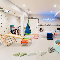 an indoor playroom with toys and accessories on the floor, including a hammock