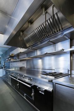 an industrial style kitchen with stainless steel cabinets and stove top ovens on both sides