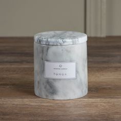 a white marble jar sitting on top of a wooden table