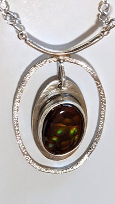 "Mexican Opal Necklace, Orange, green and gold flash in the brown Mexican opal gemstone set in an open oval of sterling silver in a one of a kind necklace. The shimmering colors make this special gem well worth a second and third look. The 20\" double diamond chain has a hand made toggle clasp for ease in wear--no tiny spring clasp to struggle with here. Pendant size overall is 1.8\" high by 1.12\" wide, hanging from a 1 inch bar. Total weight is 0.6 ounces!" Brown Oval Gemstone Jewelry, Amber Oval Pendant Jewelry, Hallmarked, Hallmarked Amber Oval Pendant Jewelry, Brown Oval Jewelry For Anniversary, Oval Brown Jewelry For Anniversary, Modern Oval Large Pendant Jewelry, Oval Opal Jewelry Collectible, Collectible Oval Opal Jewelry, Unique Oval Cabochon Jewelry