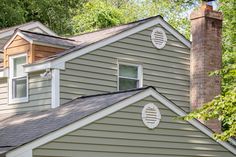 the roof of a house with two windows and a chimney in front of it on a sunny day