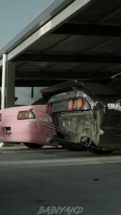 two cars that are parked next to each other in a parking garage, one is damaged and the other has it's hood ripped off