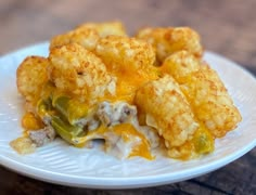 a white plate topped with tater tots covered in cheese