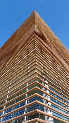 a tall wooden building with many windows on it's side and a blue sky in the background