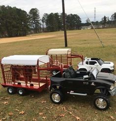 several toy trucks with sheep in them parked on the grass