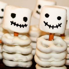 some cupcakes with marshmallow faces on them are arranged in the shape of skeletons