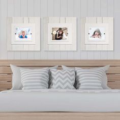 a bed with two pictures hanging on the wall above it and pillows below each one