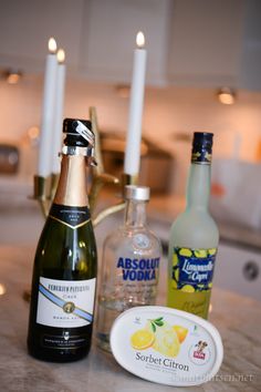 bottles of alcohol and candles sit on a counter