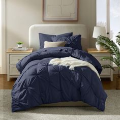 a bed with blue comforter and pillows in a room