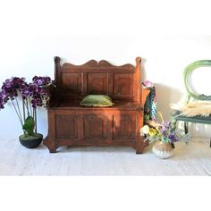 a wooden bench sitting next to a green chair and potted plant in front of it