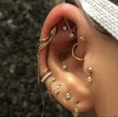 a close up of a person's ear with different types of piercings on it