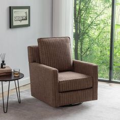 a brown chair sitting next to a table with a glass on top of it in front of a window