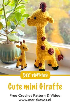 a crocheted giraffe and baby giraffe sitting on a window sill