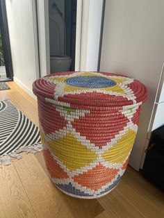 a large woven basket sitting on top of a wooden floor next to a white door