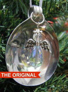 a glass ornament hanging from a christmas tree with an angel on it's side